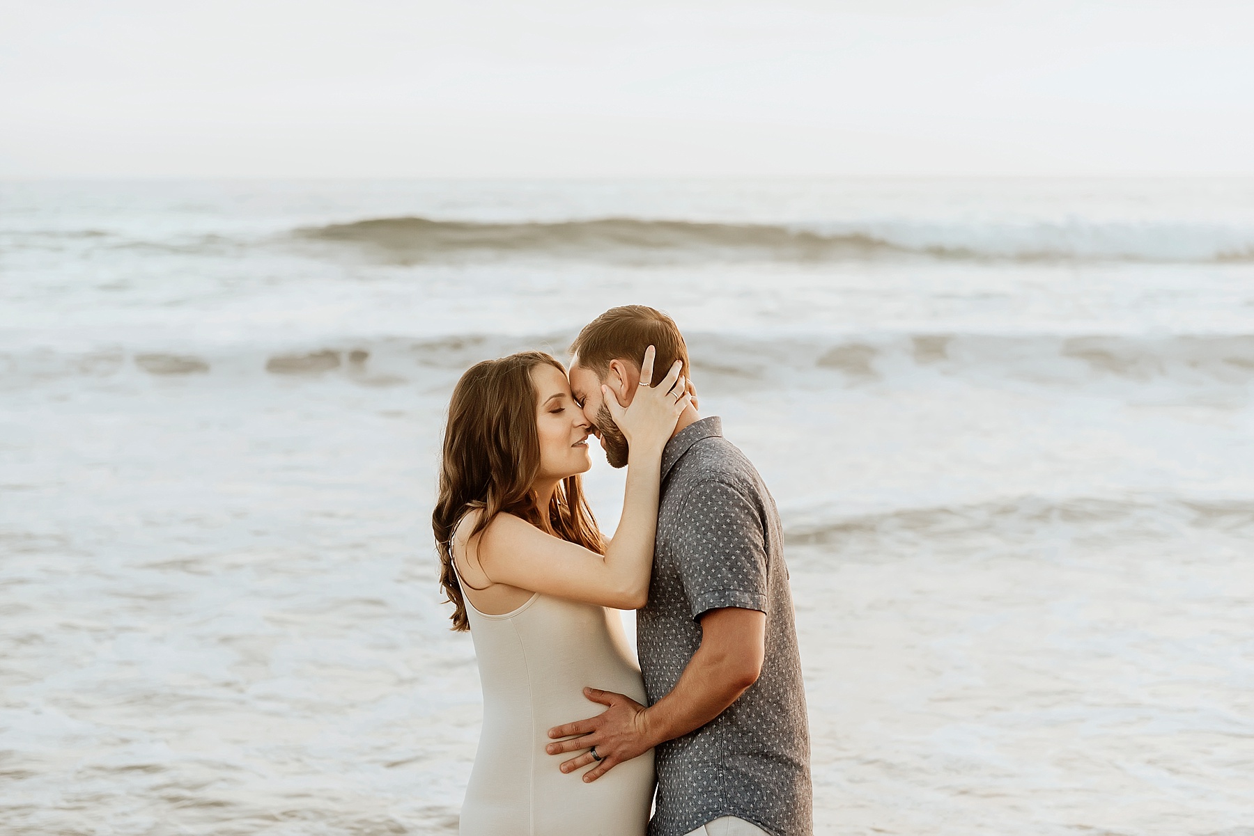 pregnancy beach photography couple kissing