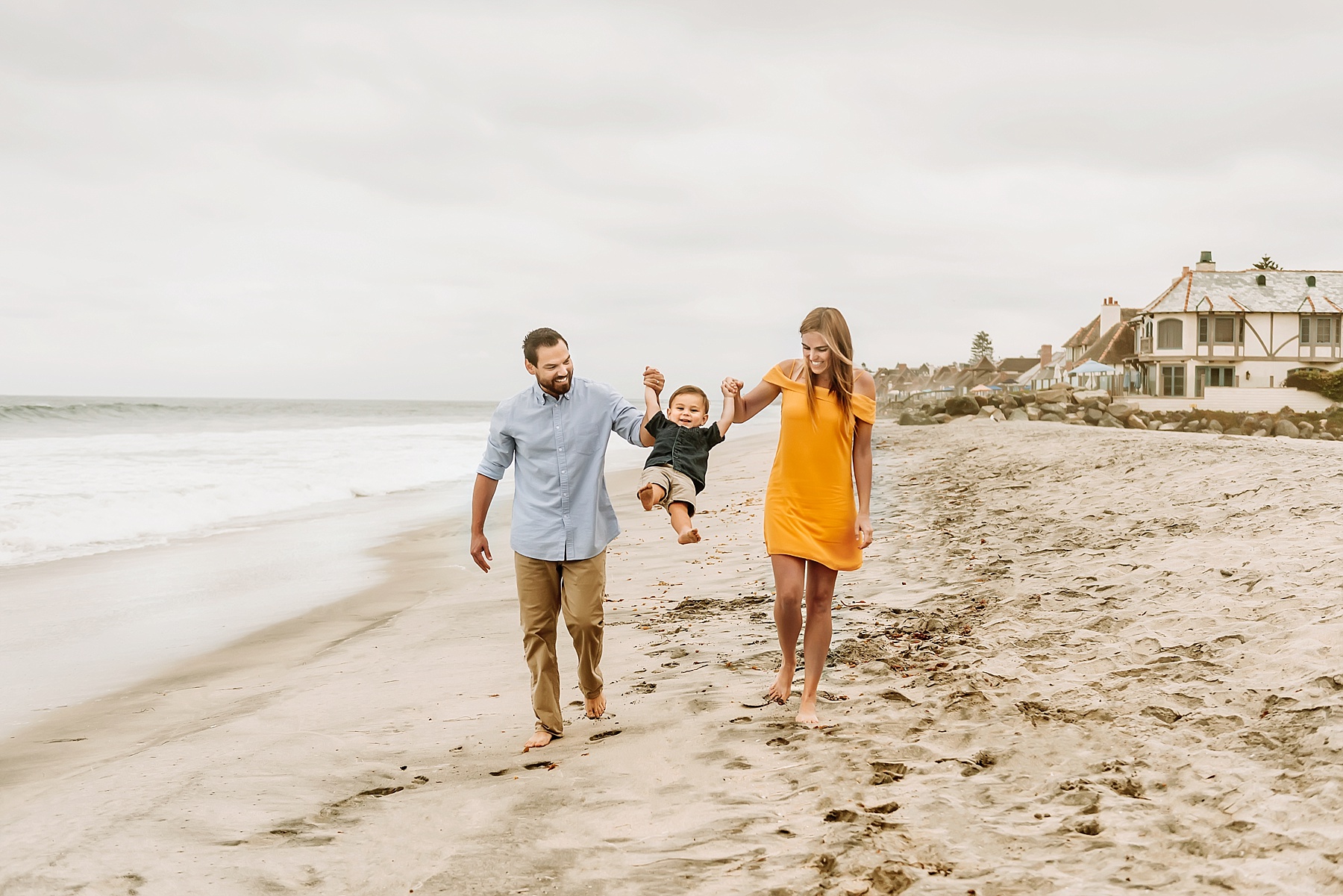 family of three beach pictures beach pictures with toddlers walking on beach swinging son
