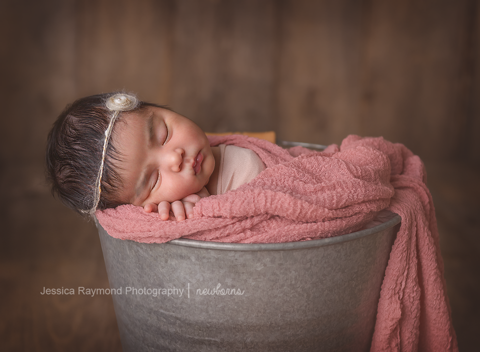 newborn photoshoot baby photo shoot posing newborn girl in bucket with pink blanket