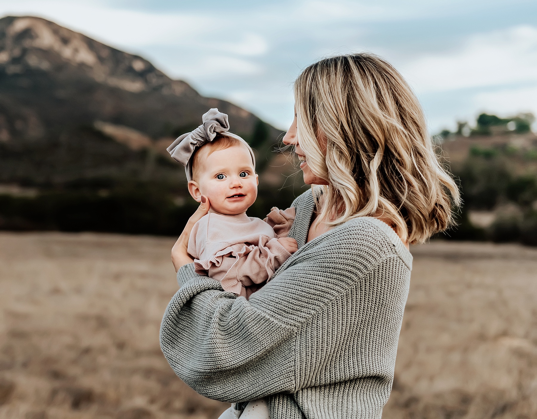 san diego family photographer mom holding baby girl in field
